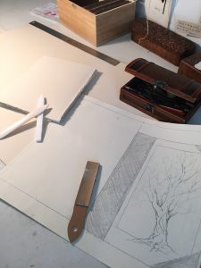 sketching preliminary designs and folding and tearing down the pages